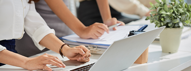 People working on a notebook and documents