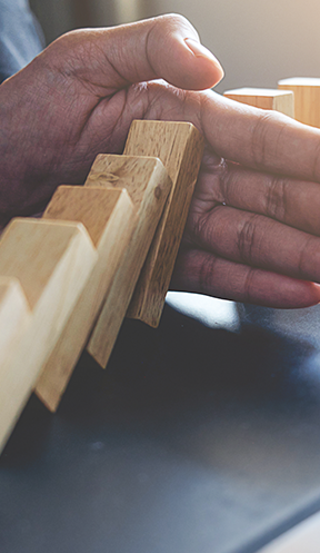 Hand stopping wooden blocks from falling