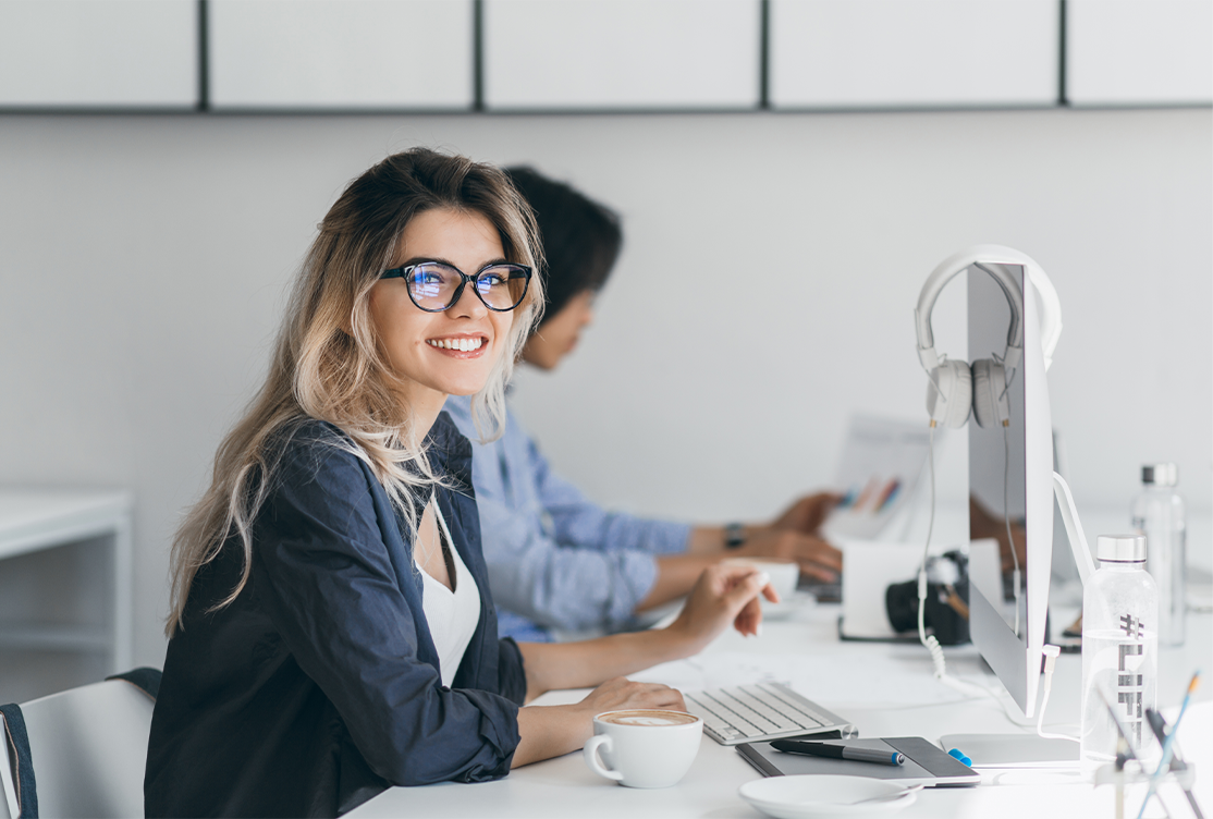 Woman smiling in the office in front oh her computer